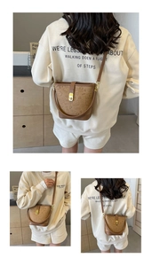 Detail view of brown vintage bucket bag with embossed cartoon patterns and gold hardware