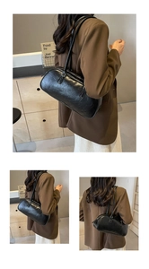 Detail of vintage black faux leather bow shoulder bag with pleated texture and dual straps