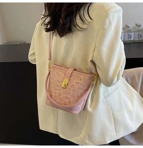 Detail of pink bucket bag with graffiti prints and a gold twist-lock metal clasp