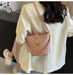 Detail of pink bucket bag featuring cute graffiti patterns and metallic twist lock closure