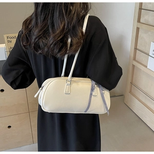 Detail of cream Boston bag with blue plaid bow and textured leather shoulder strap