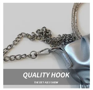 Detail view of silver metal clasp and sparkling rhinestone chain on the bucket bag