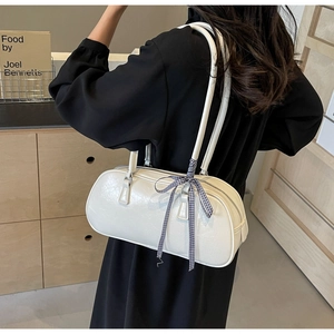 Detail of white bowling shoulder bag with pleated texture and blue checkered ribbon bow