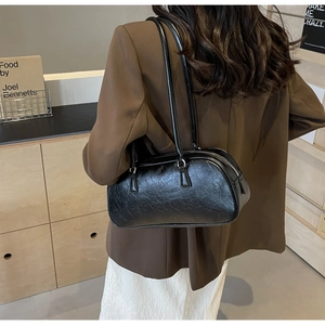 Close-up of the crinkled black leather texture and zipper detail on this hobo underarm bag