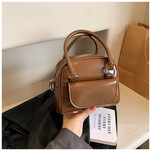 Minimalist vintage brown patent leather handbag with dual handles and shoulder strap