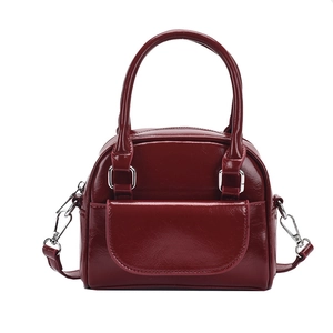 Minimalist burgundy patent leather handbag with glossy finish and detachable shoulder strap
