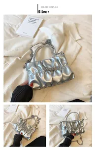 Detail of silver pleated handbag with rhinestone bow and metallic chain strap