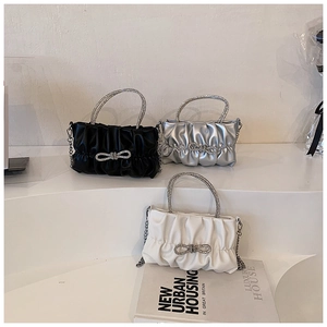 Detailed view of pleated mini bags in black, silver and white with rhinestone bows