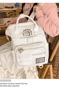 Close-up of white canvas backpack featuring KEKEMI logo and cute bread illustrations