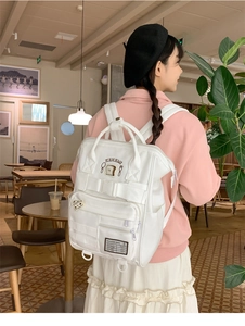 Detailed view of white large-capacity school backpack with cute bread patches and multi-pockets