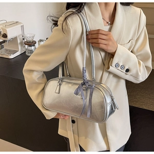 Detail of silver metallic Boston bag with wrinkled texture and blue checkered bow ribbon