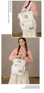 Detail of white canvas backpack featuring cute toast patches and multiple zip pockets