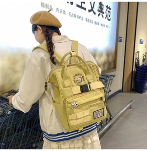 Detail of yellow school backpack with cute bread patch and spacious front pocket