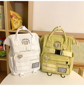 Detailed view of large capacity nylon school backpacks in white and green on a table
