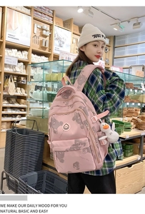 Detail view of pink backpack with bear prints and a cute plush duck charm accessory