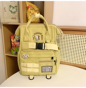 Close-up of light green canvas backpack with cute cartoon patches and sturdy straps