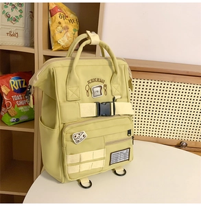 Detail of yellow nylon backpack featuring KEKEMI embroidery and functional buckles