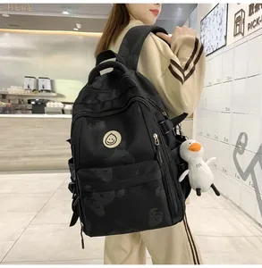 Detailed view of black printed backpack featuring bear pattern and yellow smiley face patch