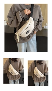Detail der cremeweißen Crossbody-Brusttasche mit verstellbarem Gurt und gewebtem Zipper