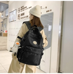 Detail of black camo backpack with adjustable padded straps and white plush duck charm