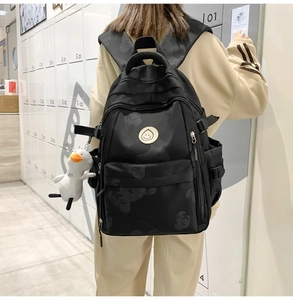 Detail of black printed backpack with side water bottle pocket and plush duck charm