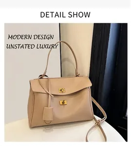 Detail view of the beige minimalist leather handbag with golden dual twist lock closure