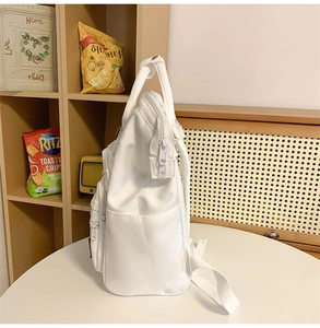 Side view of white nylon school backpack showing spacious compartments and pockets