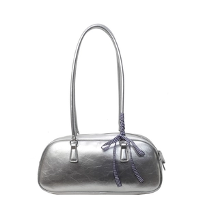 Silver metallic ballet-style handbag with bow detail and long handles on white background