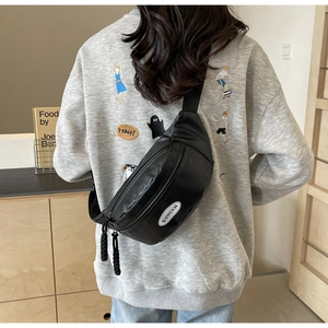 Nahaufnahme der minimalistischen schwarzen Brusttasche mit verstellbarem Riemen und Logo