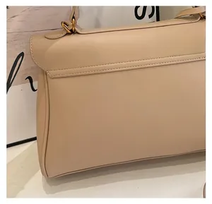 Close-up of beige leather handbag texture with golden metal ring and precise stitching