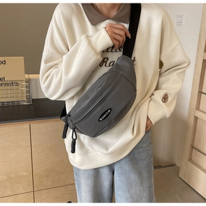 Detailansicht der grauen Brusttasche aus Nylon mit SUNIAN-Logo und gewebtem Reißverschluss