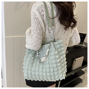 Detail of mint green bubble texture tote bag with pearl and metal chain shoulder strap