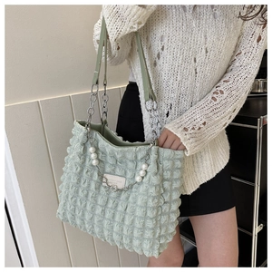 Detail of light green bubble texture tote bag with silver chain and pearl heart charm