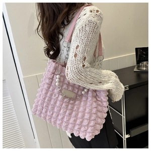 Detail of pink bubble texture tote bag with pearl chain and fashion leather label