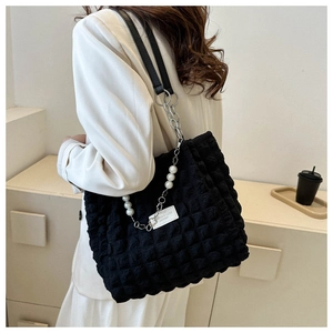 Detail of black bubble texture tote bag with pearl chain and silver metal strap