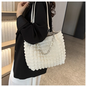 Detail of white bubble textured tote bag with pearl and silver chain handle