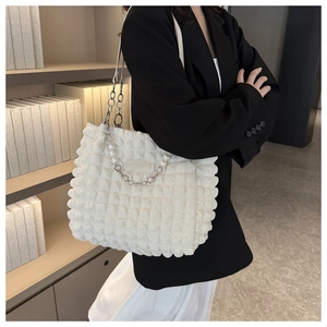 Detail of white tote bag with bubble pleated texture and pearl chain strap on model