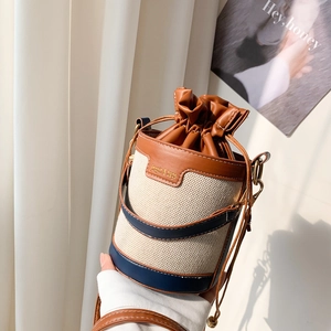 Détail du sac seau en toile bicolore avec finitions cuir et fermeture à cordon