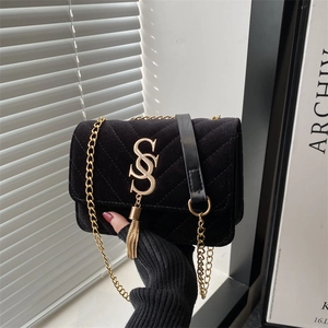 Sac bandoulière chic en velours noir matelassé avec chaîne dorée et détail de pompon