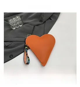 Close-up of heart-shaped orange leather coin purse with LOVE rainbow wristlet strap