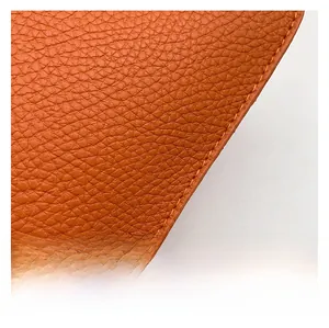 Macro detail of brown lychee grain leather with precise stitching for heart-shaped handbag