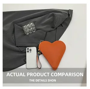 Orange heart-shaped pouch with wrist strap compared to a phone for size reference