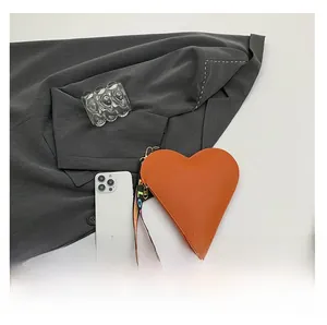Orange heart-shaped pouch with wrist strap compared to a phone for size reference