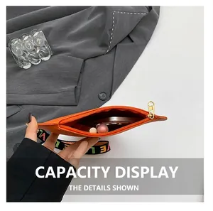 Detail view of orange leather heart bag interior showing phone and lipstick storage