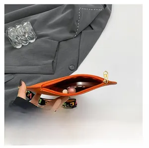 Detail view of orange leather heart bag interior showing phone and lipstick storage