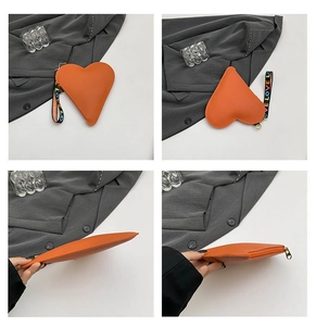 Detail view of heart-shaped orange leather coin purse with LOVE rainbow woven strap