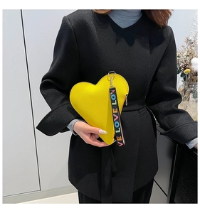 Detail of yellow heart-shaped pouch with lychee texture and colorful letter wrist strap