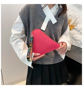 Close-up of pink heart-shaped pouch with LOVE embroidered wrist strap and pebble leather
