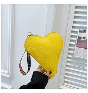 Detail of yellow heart-shaped pouch with textured faux leather and LOVE wrist strap