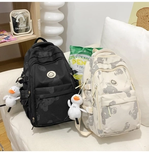 Detail of a large casual backpack with bear print and cute plush duck keychain accessory